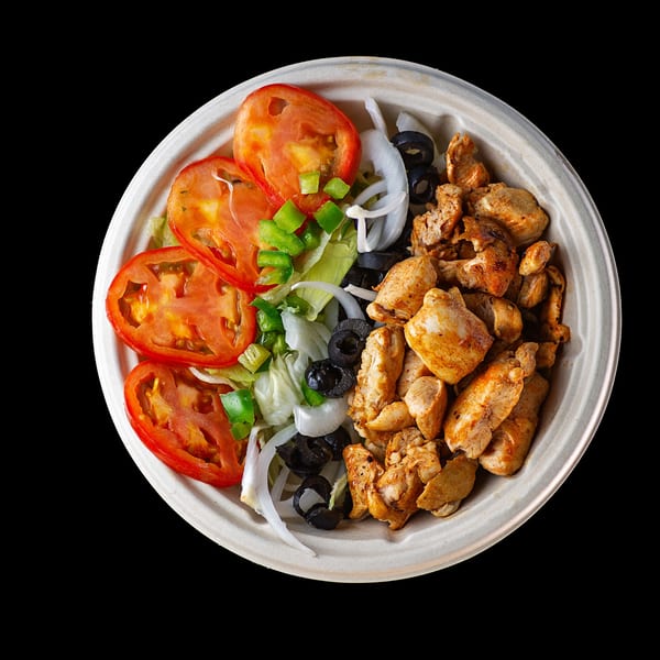 A bowl of grilled chicken, sliced tomatoes, lettuce, onions, green peppers, and black olives.